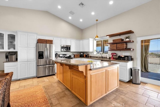 kitchen featuring a center island, stainless steel appliances, visible vents, white cabinetry, and high vaulted ceiling