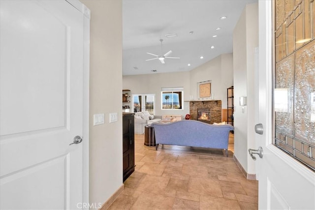 bedroom with recessed lighting, baseboards, stone finish flooring, and a glass covered fireplace