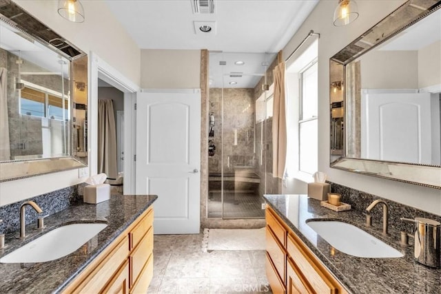 full bathroom featuring two vanities, a sink, visible vents, and a shower stall