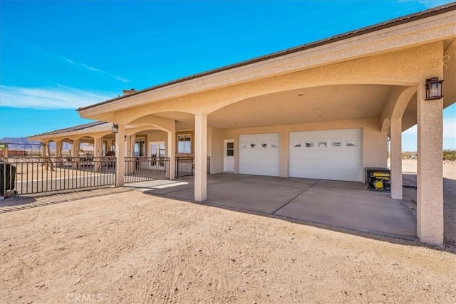 exterior space with driveway, fence, and stucco siding