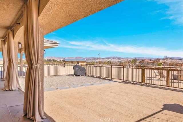 view of patio / terrace featuring fence and a mountain view