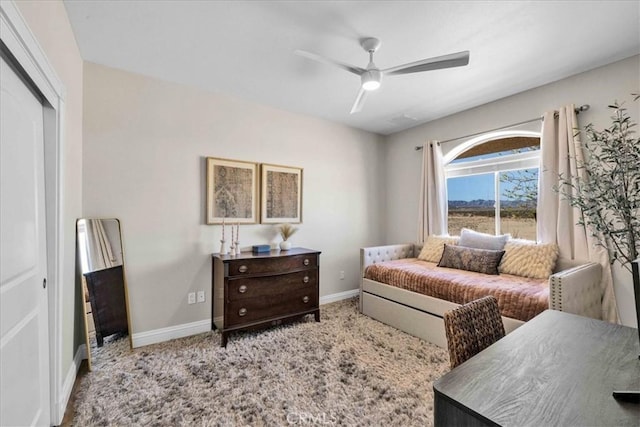 carpeted bedroom featuring a ceiling fan, a closet, and baseboards