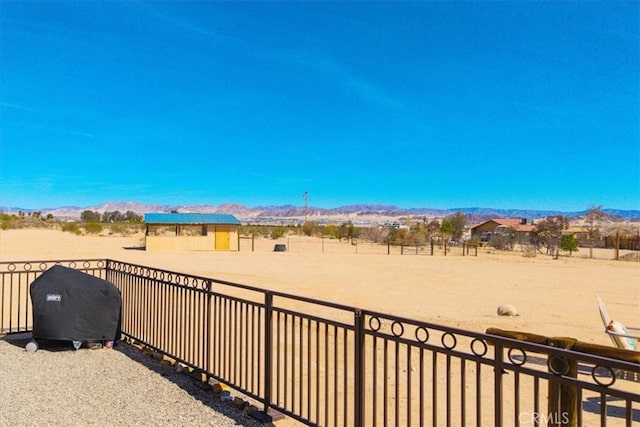 view of yard featuring fence and a mountain view