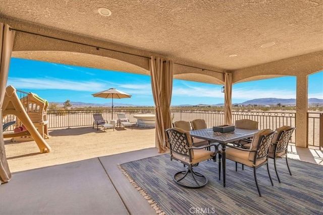 view of patio / terrace featuring outdoor dining space and a mountain view