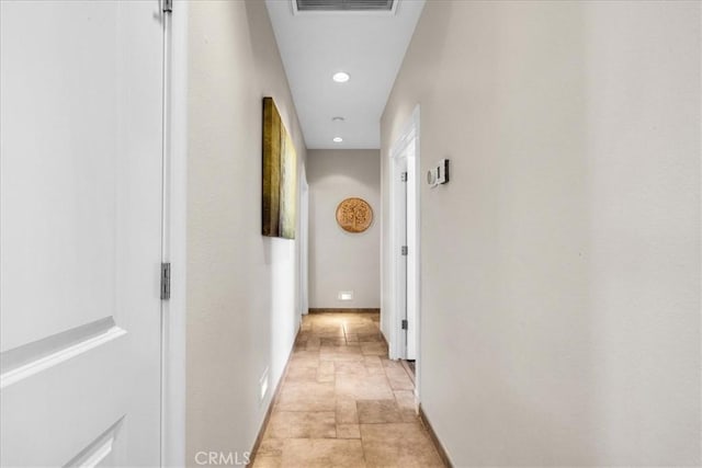 corridor featuring recessed lighting, stone finish flooring, visible vents, and baseboards