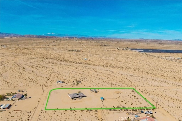 drone / aerial view featuring view of desert, a rural view, and a mountain view