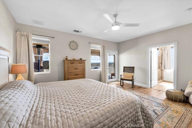 bedroom featuring visible vents, ceiling fan, baseboards, and wood finished floors