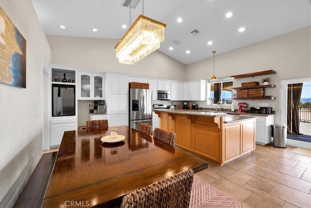 kitchen with visible vents, white cabinets, a kitchen island, stainless steel appliances, and open shelves