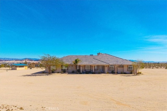 rear view of property featuring a mountain view and stucco siding