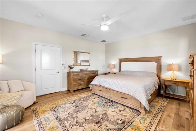 bedroom with light wood-style flooring, visible vents, and a ceiling fan