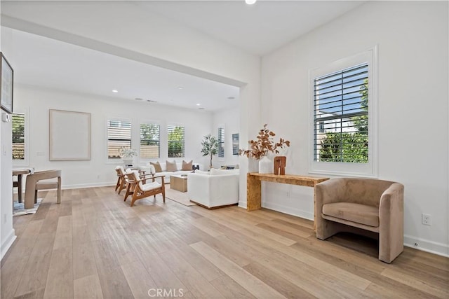 living area featuring recessed lighting, light wood-type flooring, and baseboards