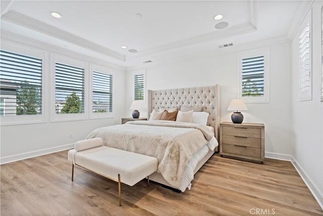 bedroom with multiple windows, a tray ceiling, and crown molding