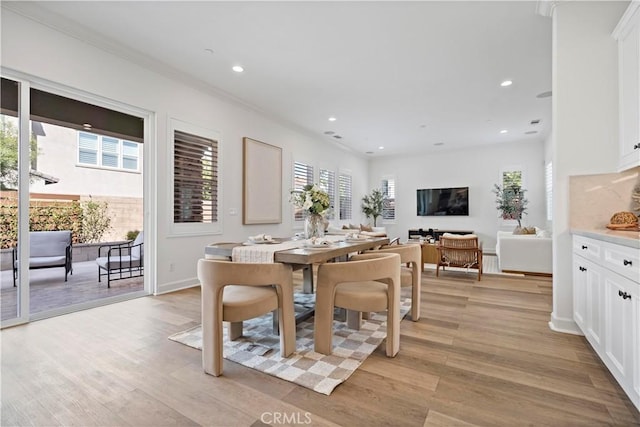 dining area featuring light wood-style floors, crown molding, and recessed lighting