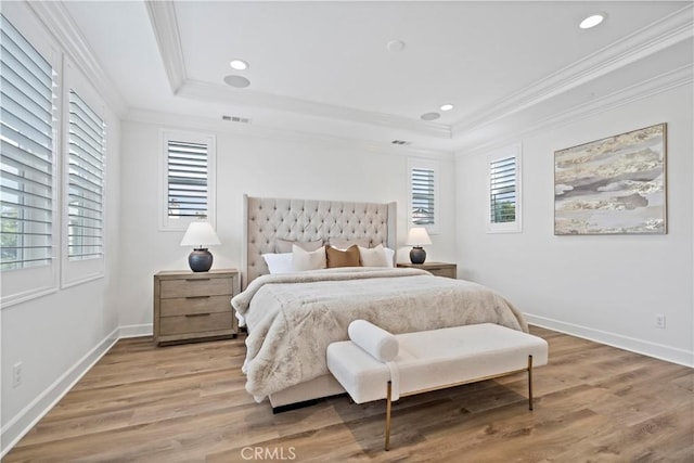 bedroom featuring crown molding, recessed lighting, a raised ceiling, light wood-style flooring, and baseboards