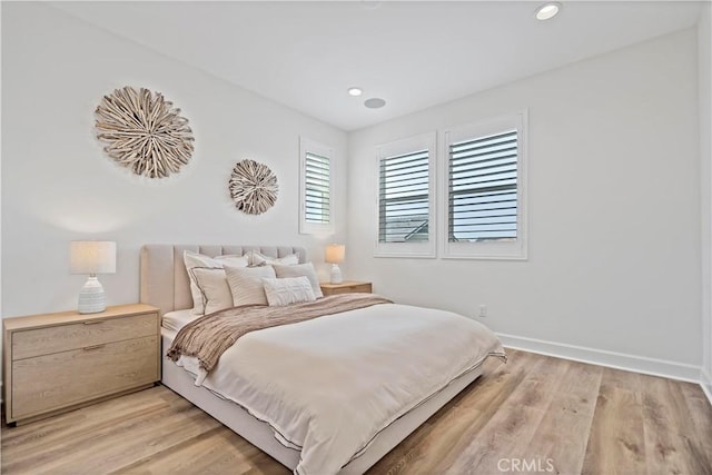 bedroom featuring light wood finished floors, baseboards, and recessed lighting