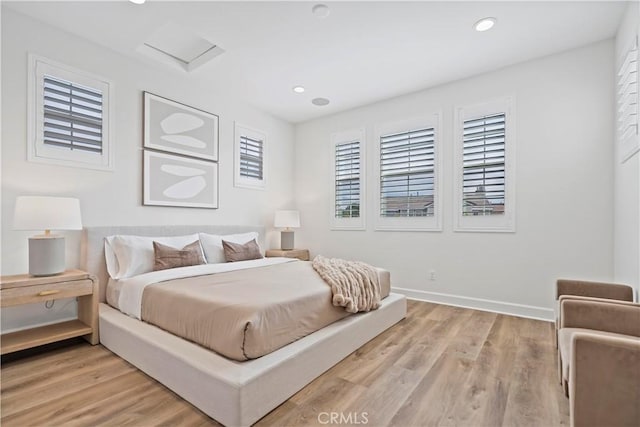 bedroom featuring attic access, recessed lighting, light wood-style floors, and baseboards