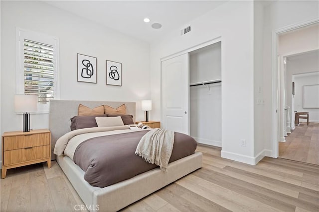 bedroom with baseboards, visible vents, light wood-type flooring, a closet, and recessed lighting