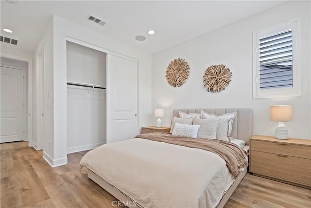 bedroom featuring a closet, visible vents, and light wood finished floors