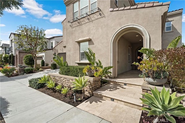 property entrance with a tiled roof and stucco siding