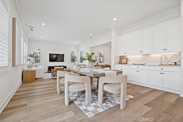 dining space with light wood-style floors, recessed lighting, and ornamental molding