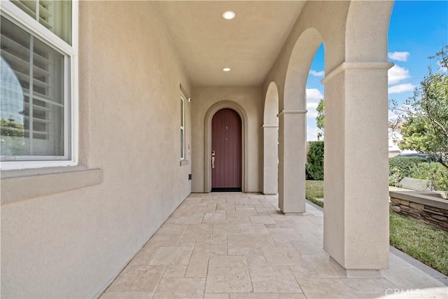 property entrance with a patio and stucco siding