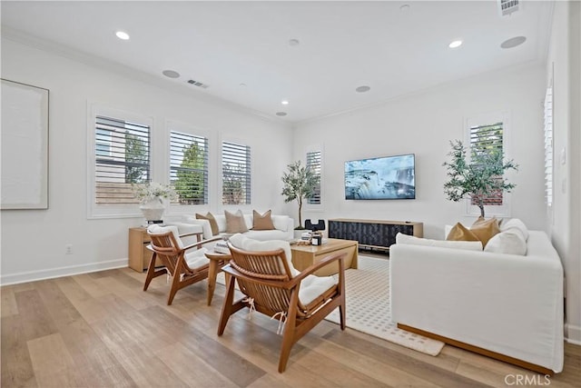 living area with ornamental molding, light wood-type flooring, visible vents, and recessed lighting