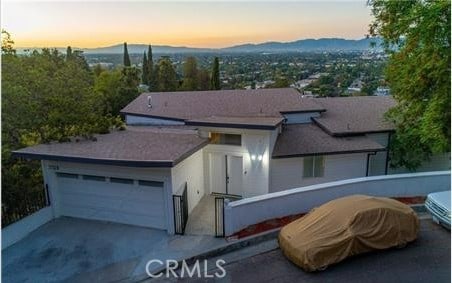 view of front of home with a garage, driveway, and a mountain view