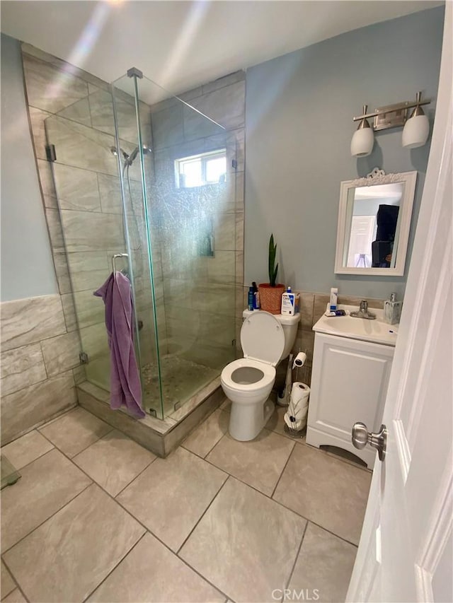 full bath featuring tile patterned floors, a shower stall, vanity, and toilet
