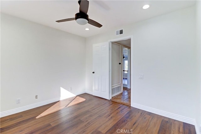 unfurnished room with recessed lighting, wood finished floors, visible vents, and baseboards