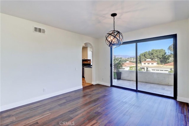 unfurnished room featuring baseboards, visible vents, arched walkways, dark wood-style flooring, and a chandelier