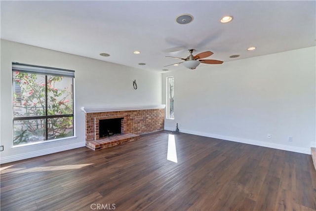 unfurnished living room featuring a fireplace, baseboards, dark wood-style flooring, and recessed lighting