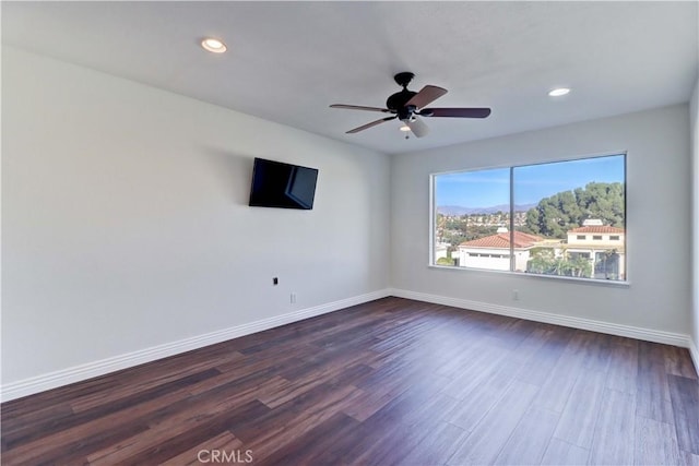 empty room with recessed lighting, dark wood-style flooring, ceiling fan, and baseboards