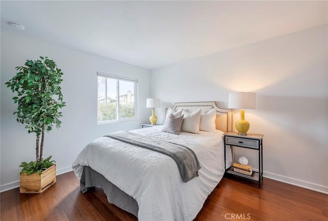 bedroom featuring dark wood-style flooring and baseboards