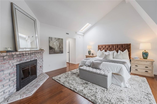 bedroom with a brick fireplace, dark wood finished floors, visible vents, and baseboards