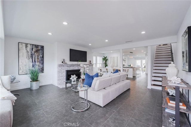 living room featuring recessed lighting, stairway, a brick fireplace, dark tile patterned flooring, and baseboards