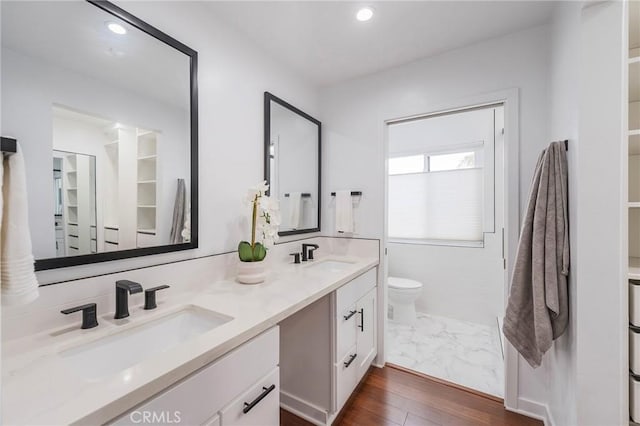 full bath featuring recessed lighting, a sink, toilet, and double vanity