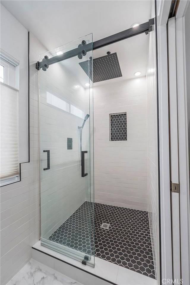 full bath featuring marble finish floor and a shower stall