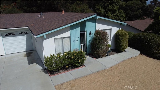 view of front of house with an attached garage and a shingled roof