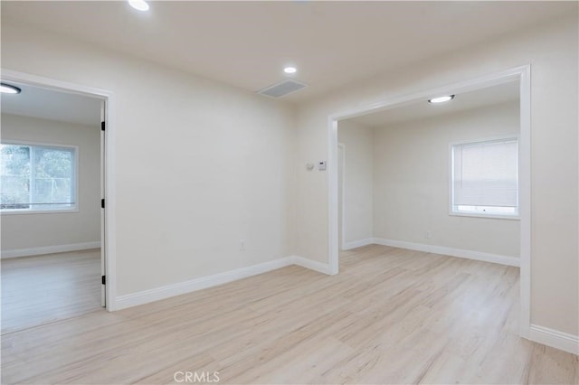 unfurnished room with visible vents, recessed lighting, light wood-style flooring, and baseboards