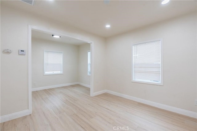 spare room featuring light wood finished floors, recessed lighting, visible vents, and baseboards