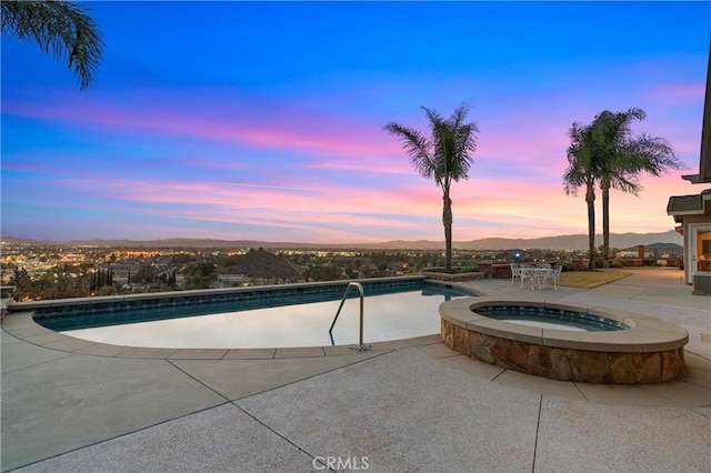 view of pool with a patio area and a pool with connected hot tub