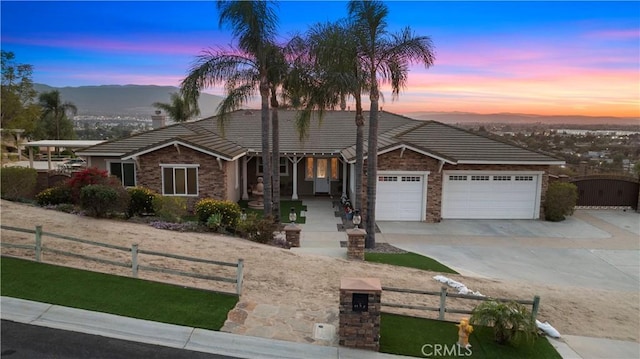 view of front of home featuring concrete driveway, a fenced front yard, an attached garage, and a gate