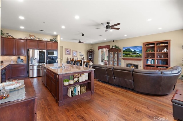 kitchen featuring stainless steel appliances, open floor plan, and dark wood-style floors