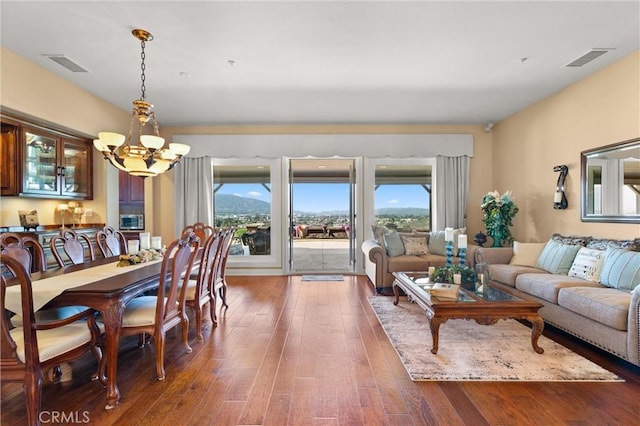 dining room with an inviting chandelier, visible vents, and wood finished floors