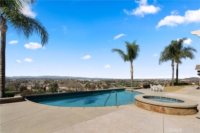 view of pool with a patio area and a pool with connected hot tub