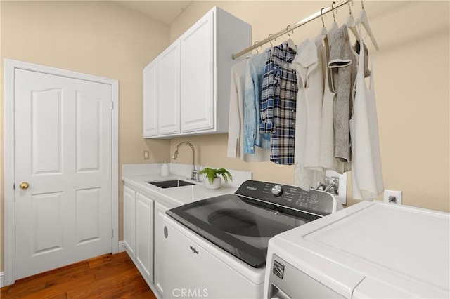 laundry room with dark wood finished floors, washer and clothes dryer, a sink, and cabinet space