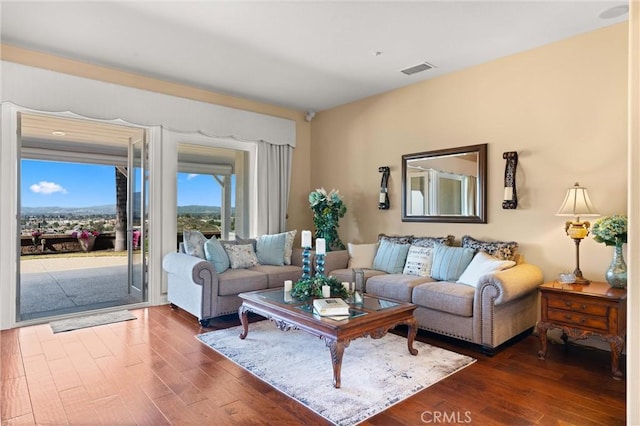 living room featuring dark wood-style flooring and visible vents