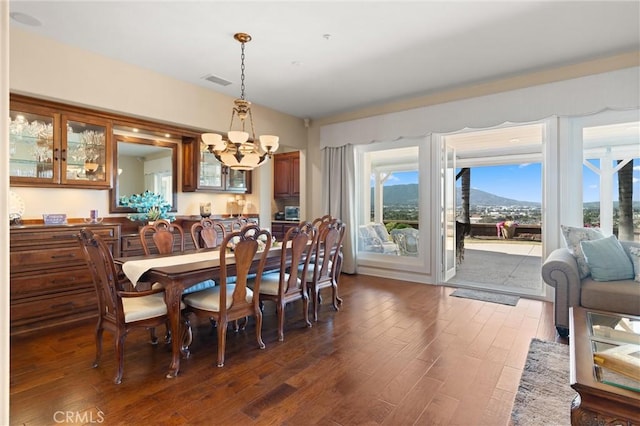 dining space with a chandelier, dark wood-style flooring, and visible vents