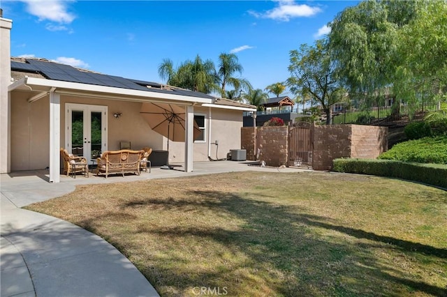 back of house featuring fence, french doors, a lawn, a gate, and stucco siding