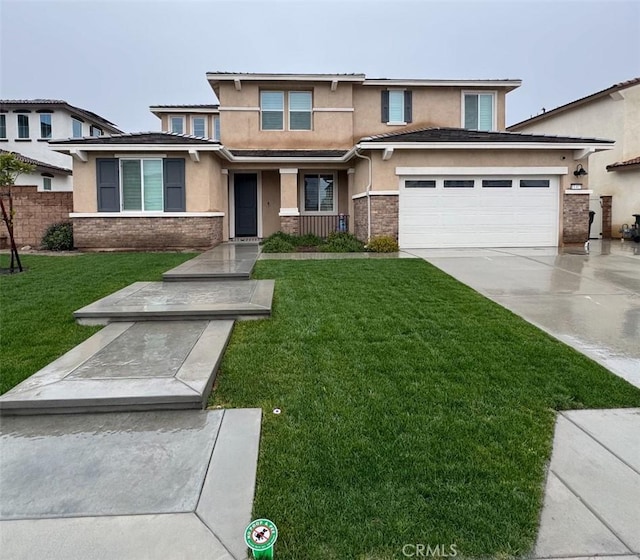 prairie-style house featuring a front lawn, concrete driveway, stone siding, and stucco siding